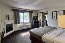 Traverse Blossom hotel King Two Room bedroom with king bed, desk, fireplace, and TV